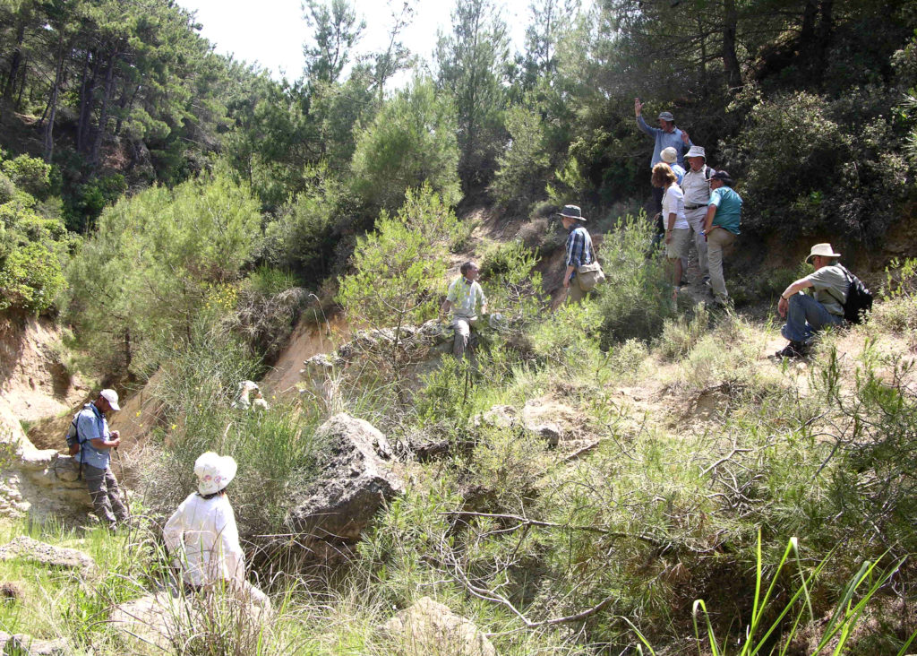 The famed Gully Ravine., Gallipoli Visitors rest at the natural rock wall. The trail is rugged and the short wall must be scaled. On the other side (out of view), a pond - best avoided after climbing over the wall.