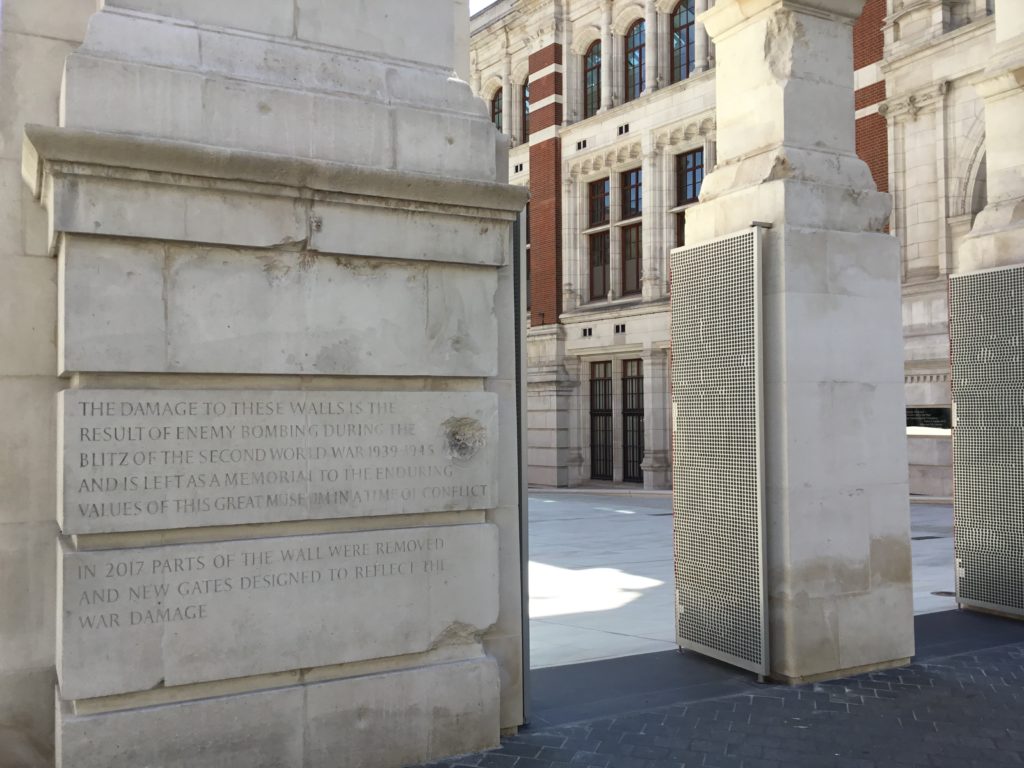 Exterior of the Victoria and Albert Museum showing damage caused by enemy bombing during the London Blitz. The corner wall is inscribed with details of the action.