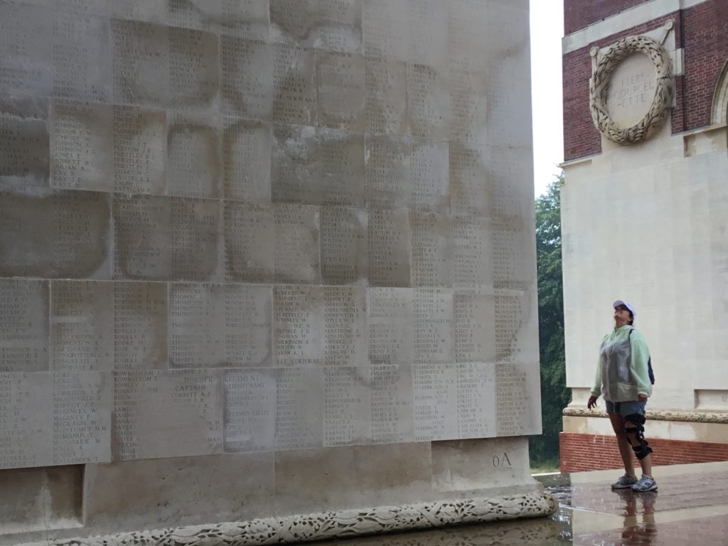 A visitor to the Thiepval War Memorial looks up at a panel of names commemorating the fallen. It has been raining.