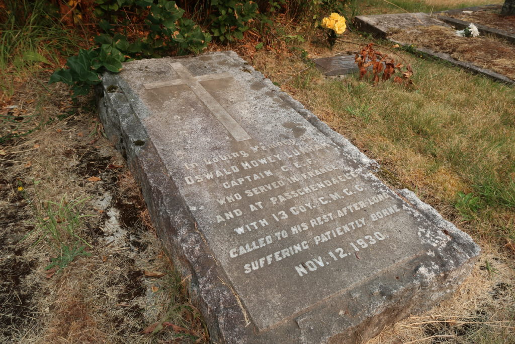 The lettered full length grave marker of Captain Lunham in the churchyard cemetery at Cowichan Station. The marker includes a large cross above the inscription.