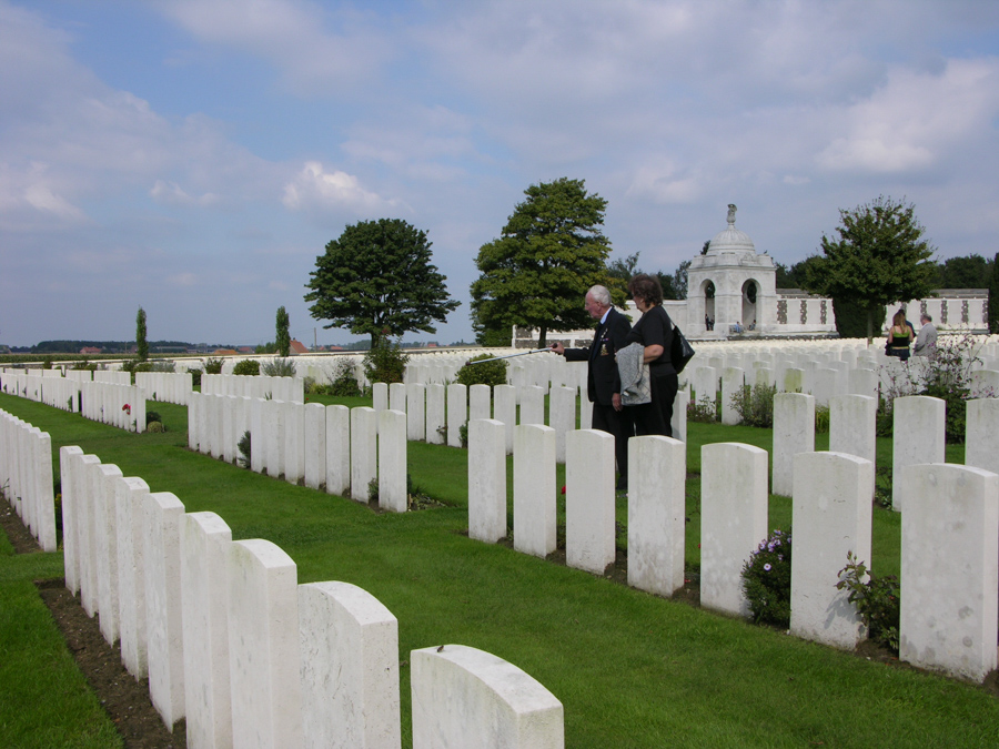 People stand amongst headstone at Tyne Cot Cemetery, Belgium.