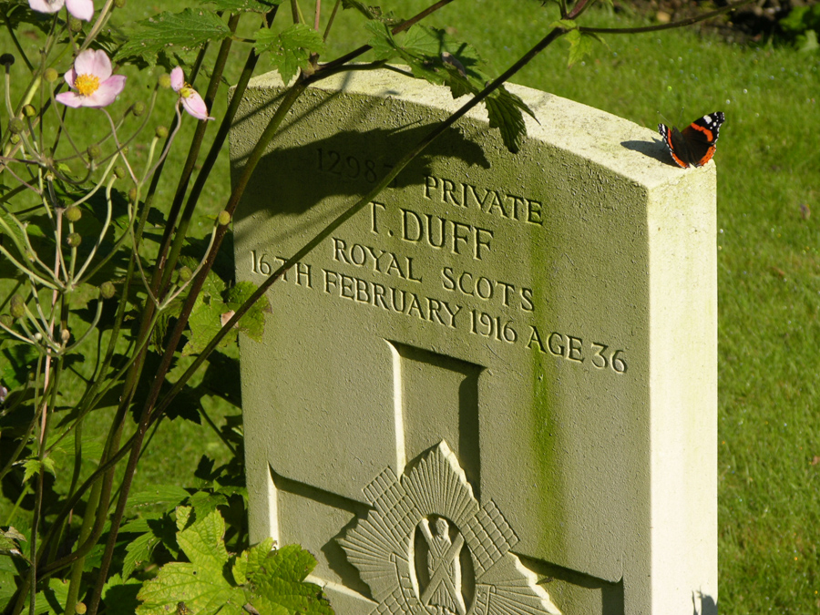 Private T. Duff's headstone at the Rifle House Cemetery, Belgium with a butterfly.
