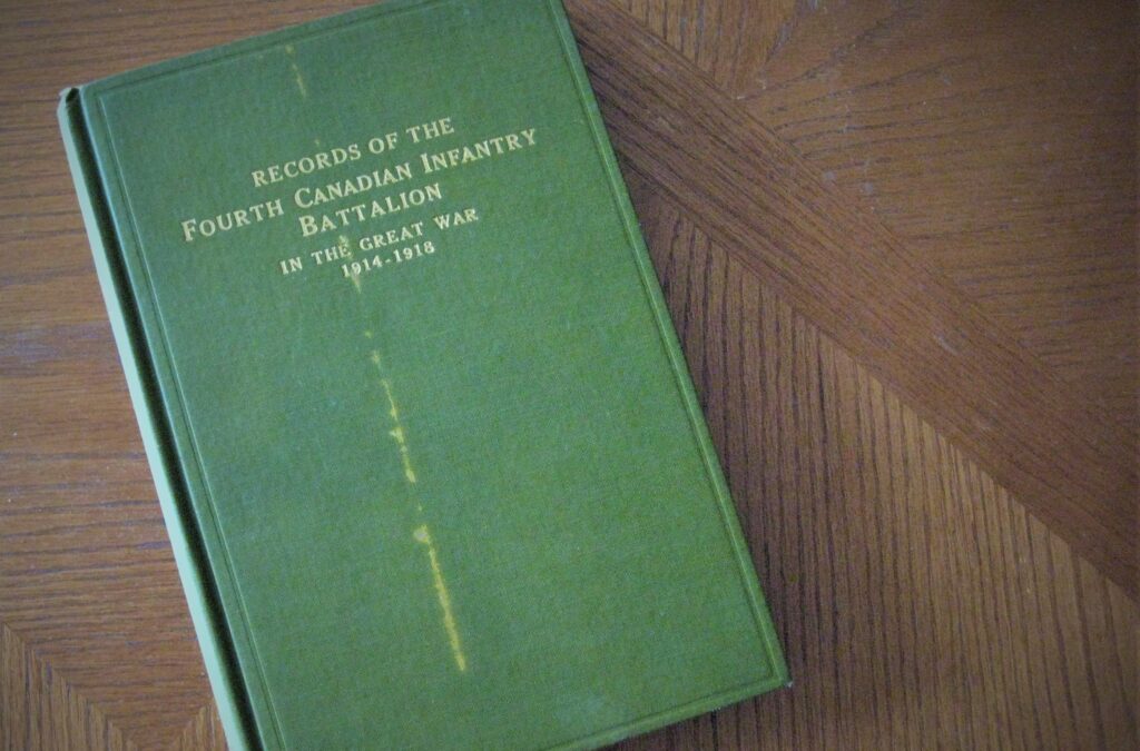 A green hard cover book with gold lettering lies upon a wood table., Records of the Fourth Canadian Infantry Battalion. Most probably once owned by a soldier of the battalion.