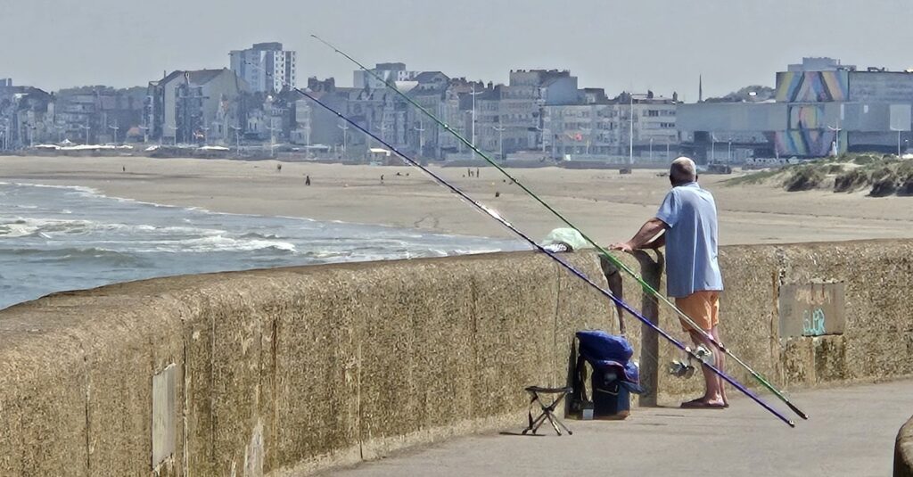 Fisherman on the mole looks back towards the beach at Dunkirk.
